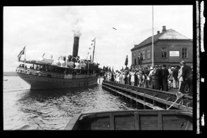 DS Jarlsberg legger til ved Brygga i 1930- årene ved Tollboden. Ut fra flaggene i folkemengden kan det være i forbindelse med en politisk markering i regi av Arbeiderpartiet. (Utlånt av Slottsfjellsmuseet)